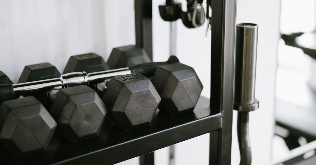 Close-up of gym equipment including dumbbells on a storage rack, perfect for fitness-themed uses.