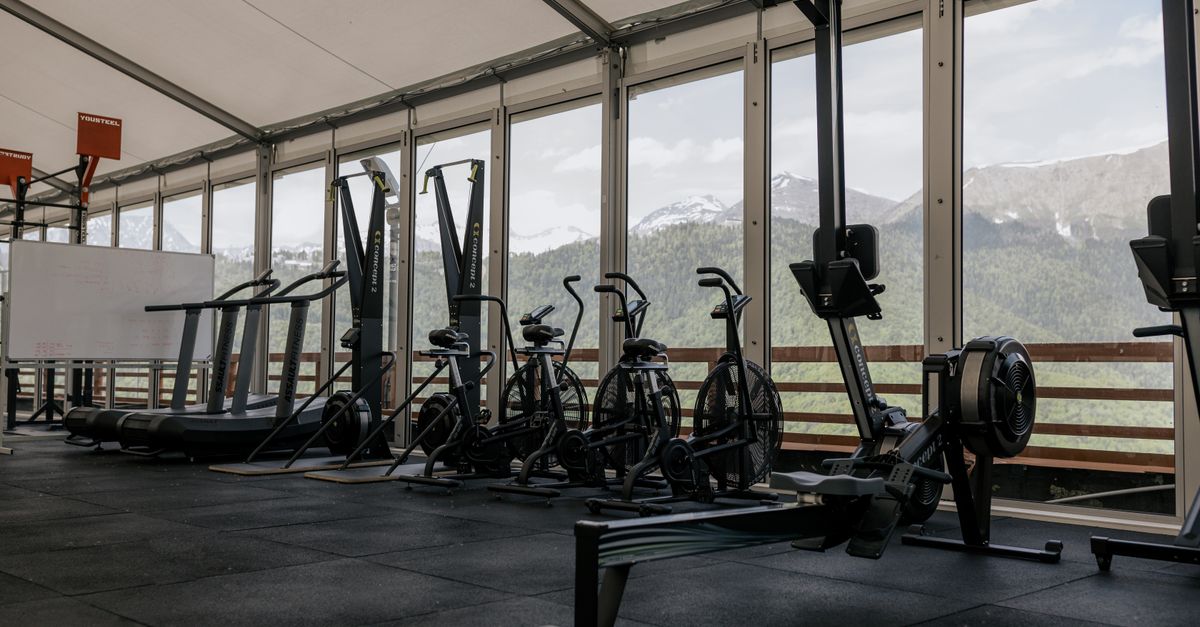 Spacious indoor gym featuring state-of-the-art equipment with scenic mountain views outside large windows.